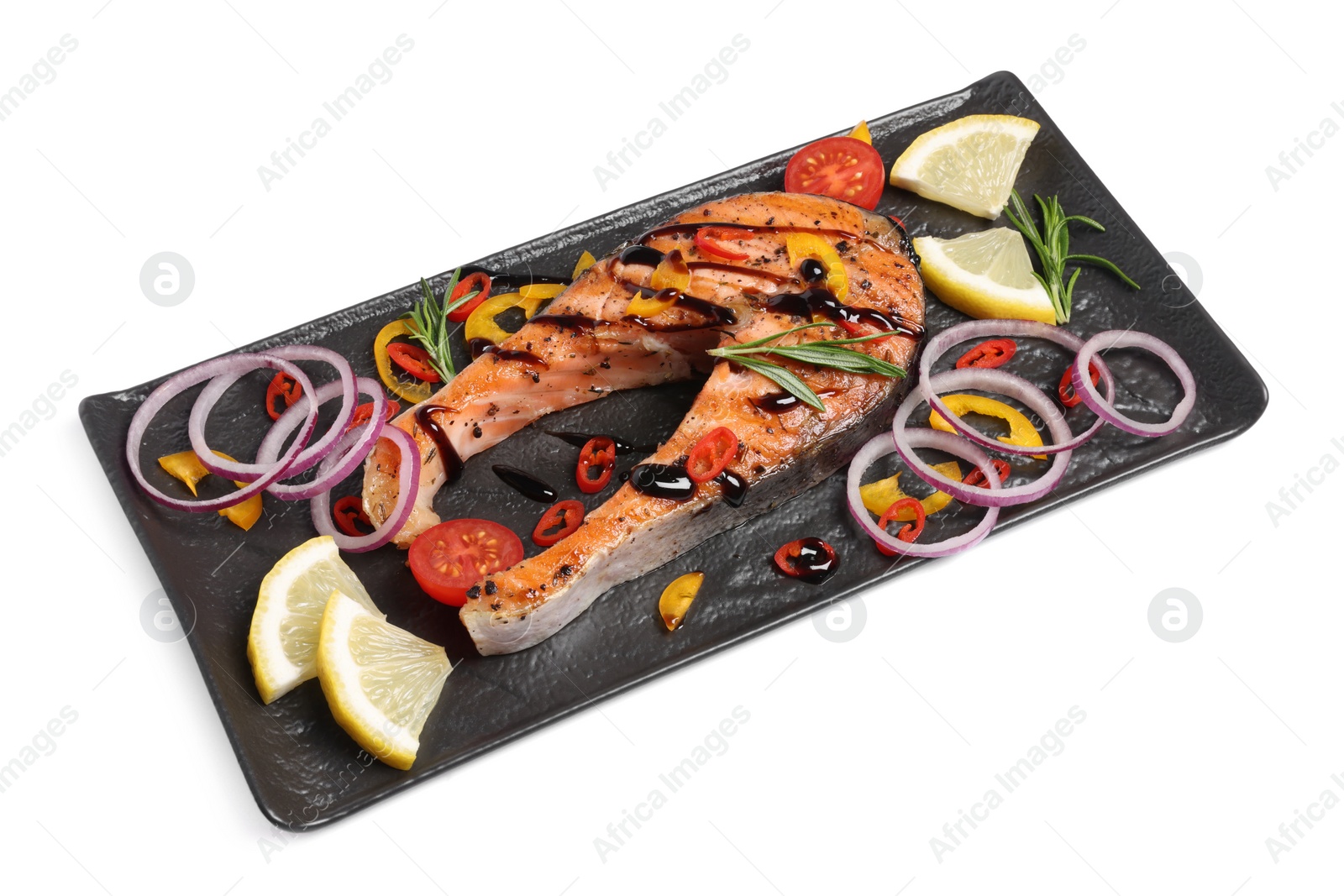 Photo of Slate plate with tasty salmon steak, lemon and vegetables isolated on white