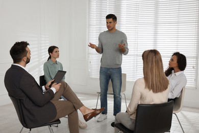 Photo of Psychotherapist working with patients at group session indoors