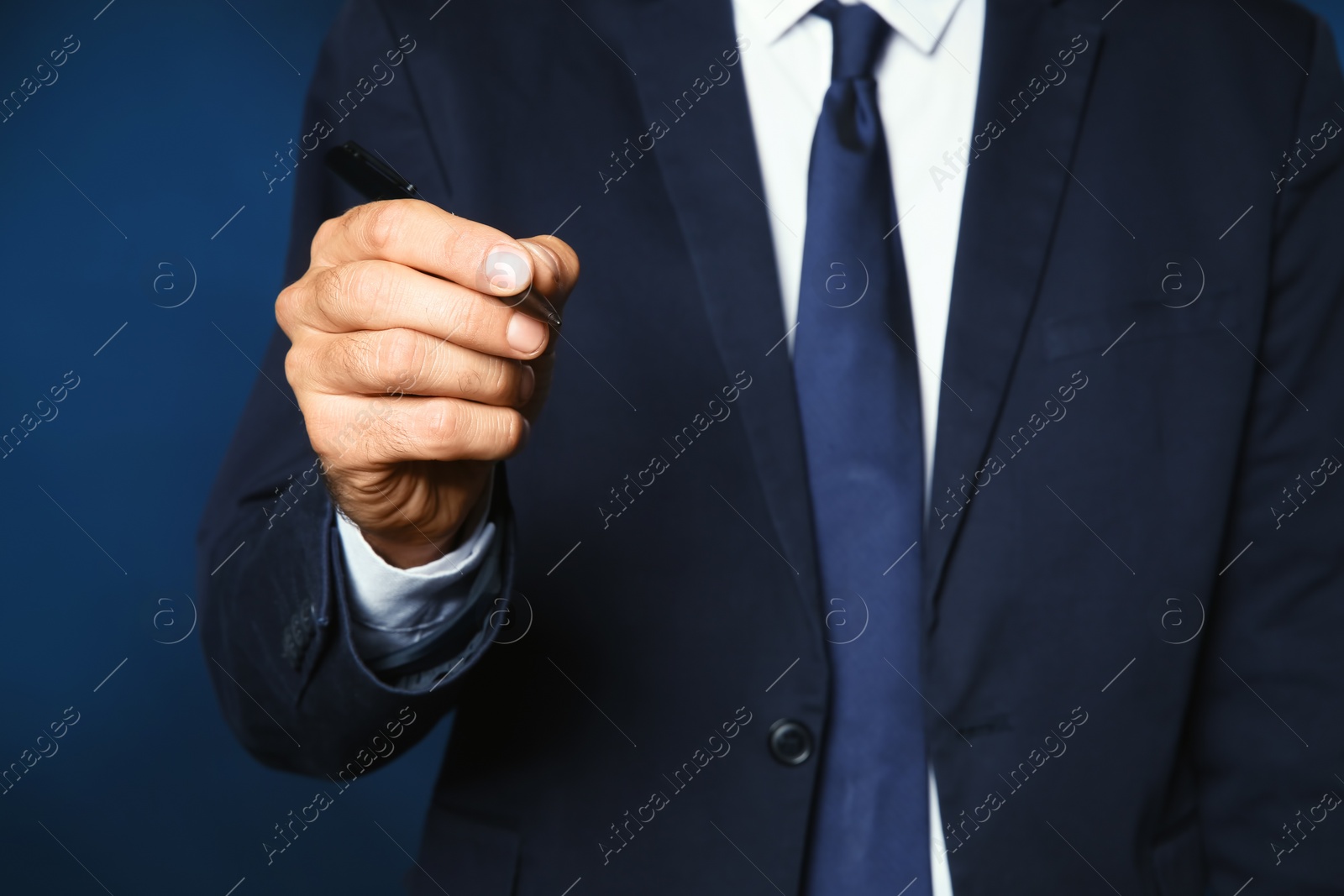Photo of Businessman writing against color background, closeup view