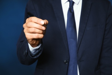 Businessman writing against color background, closeup view