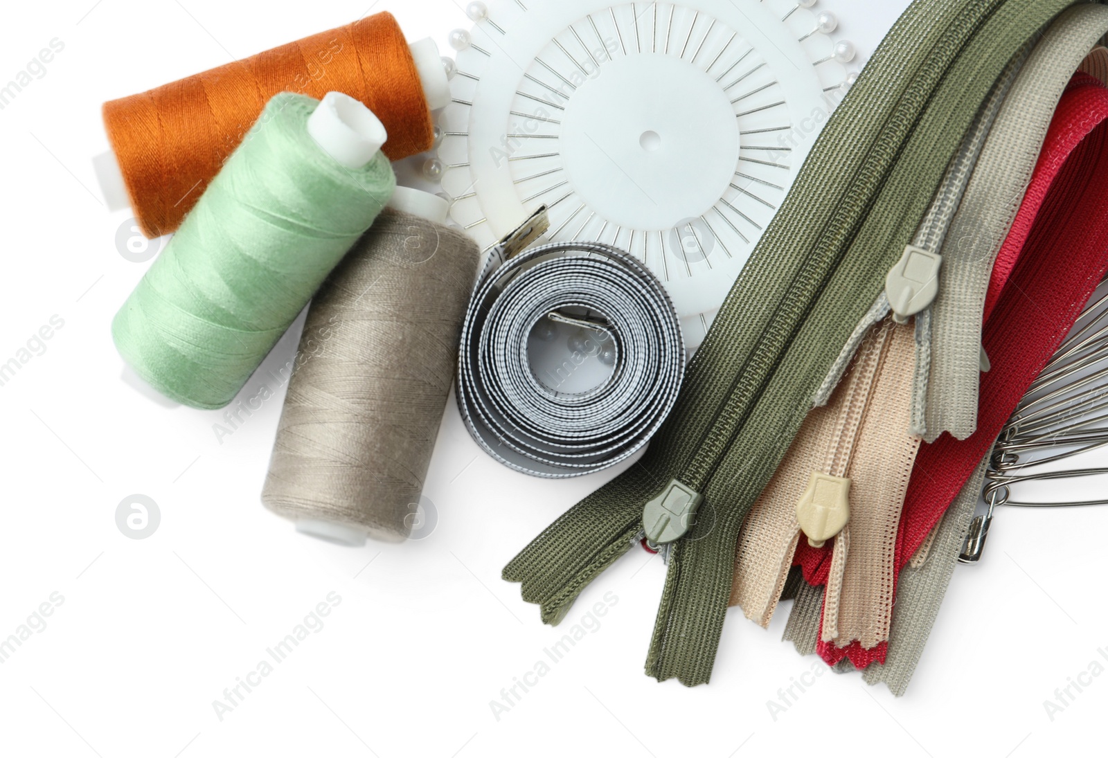 Photo of Spools of threads and sewing tools on white background, top view