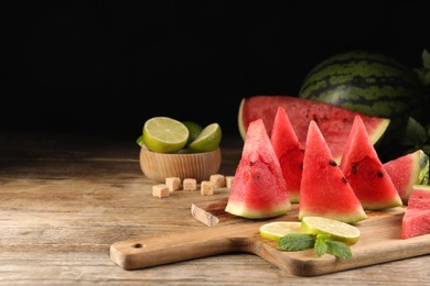 Photo of Tasty juicy watermelon and lime slices on wooden table, space for text