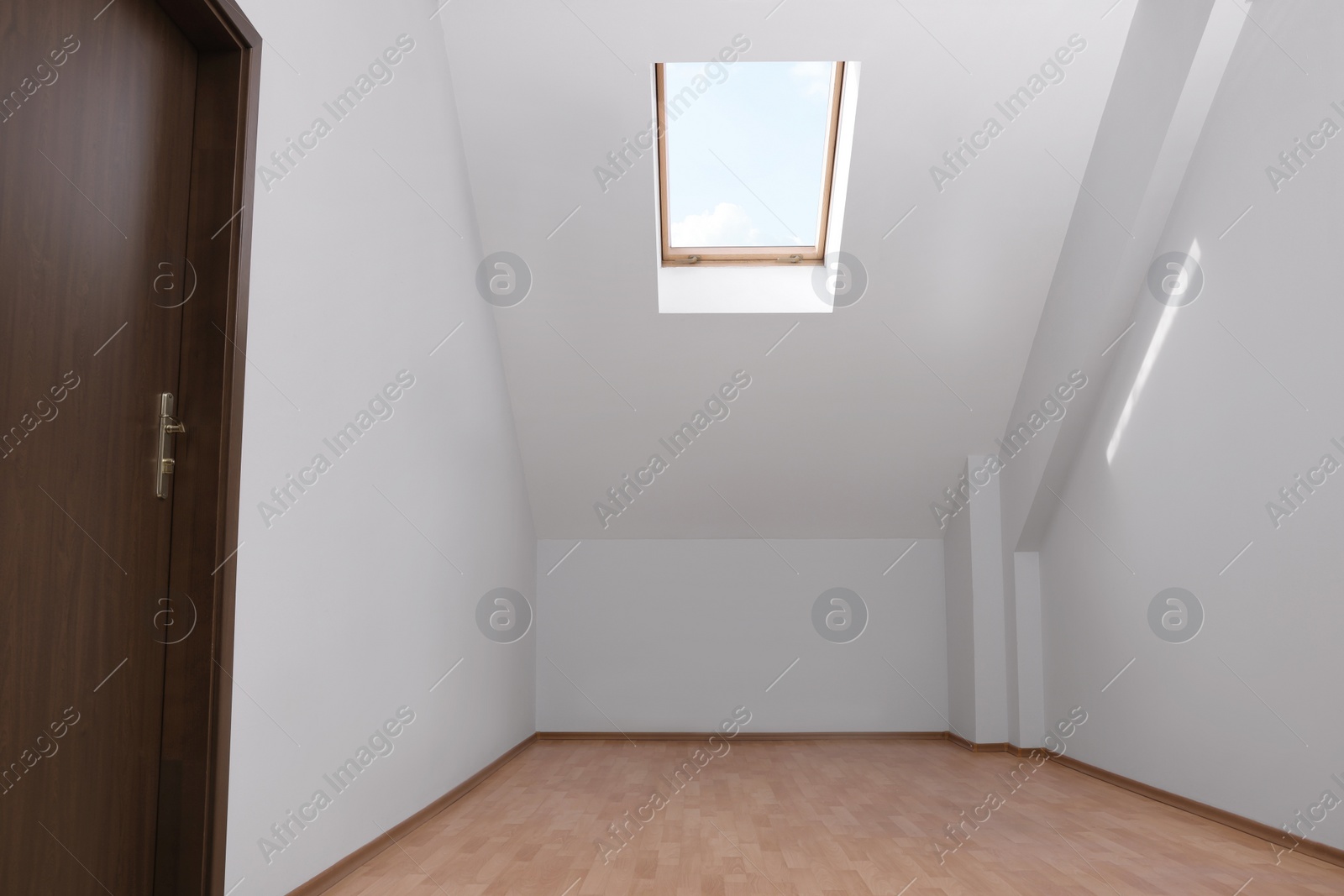 Photo of Light spacious attic room with window on slanted ceiling