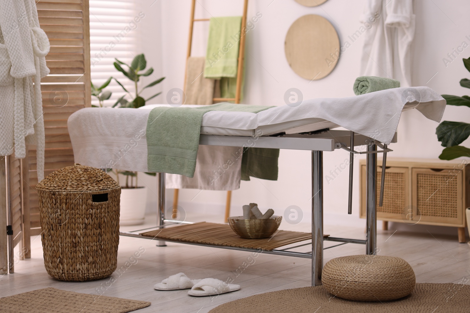 Photo of Comfortable massage table with clean towels in spa center