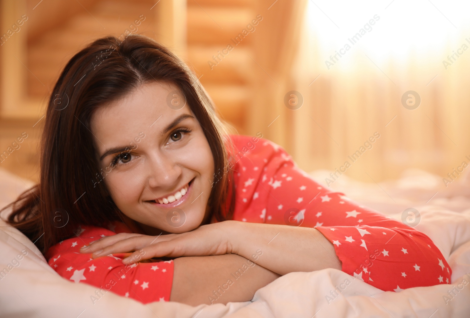 Photo of Young woman lying in bed at home. Lazy morning