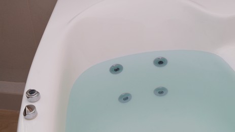 Photo of Hot tub with clean water in bathroom