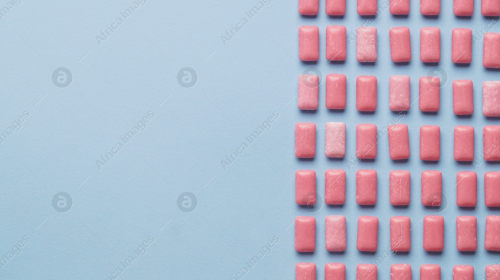 Photo of Many sweet chewing gums on light blue background, flat lay. Space for text