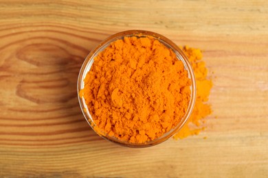 Photo of Aromatic saffron powder in bowl on wooden table, top view