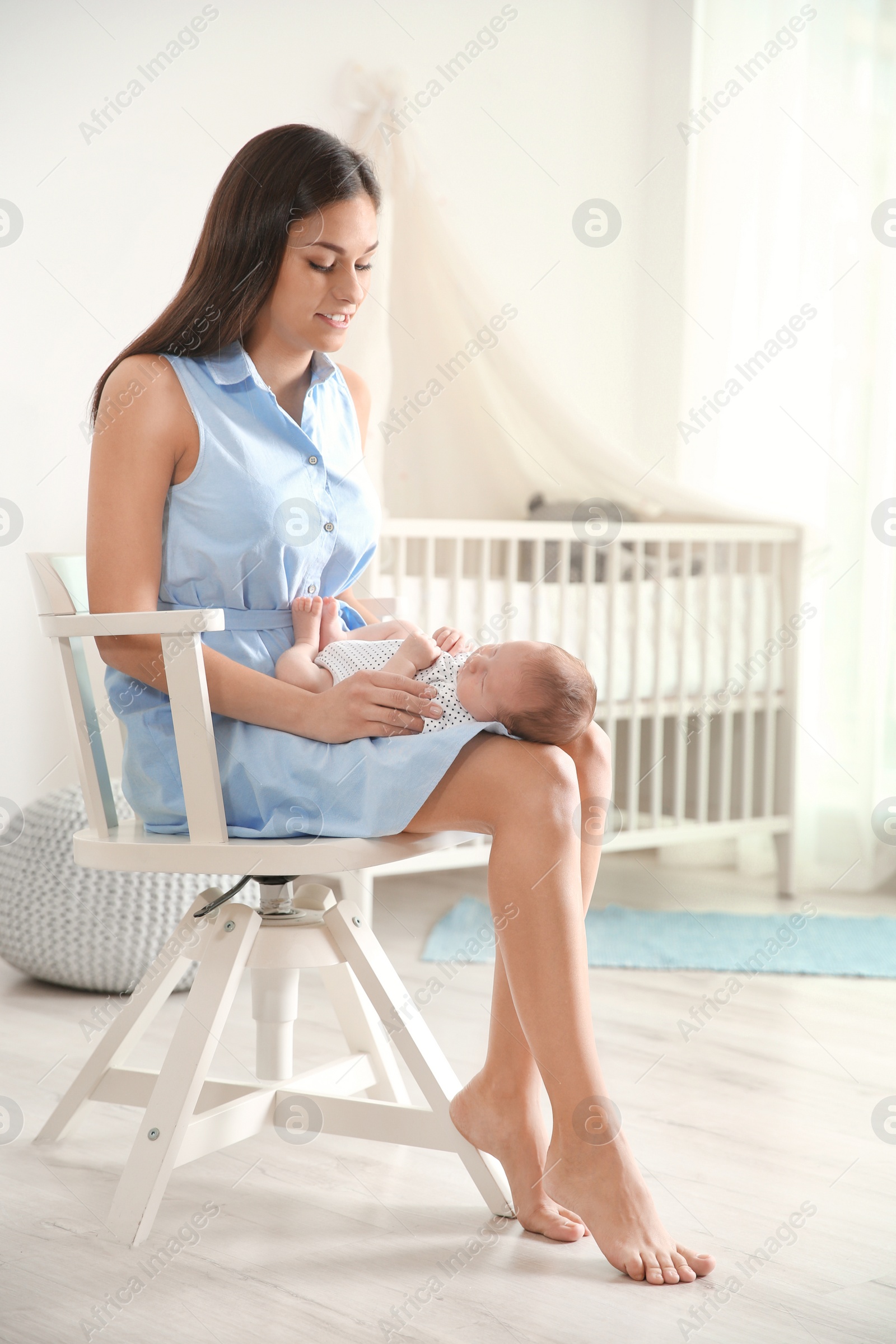 Photo of Young woman with her newborn baby at home