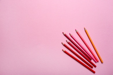 Photo of Color pencils on pink background, flat lay. Space for text