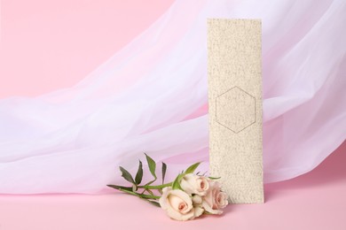 Photo of Scented sachet, roses and fabric on pink background