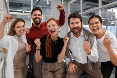 Photo of Team of employees celebrating success in office