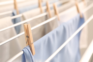 Clean laundry hanging on drying rack, closeup