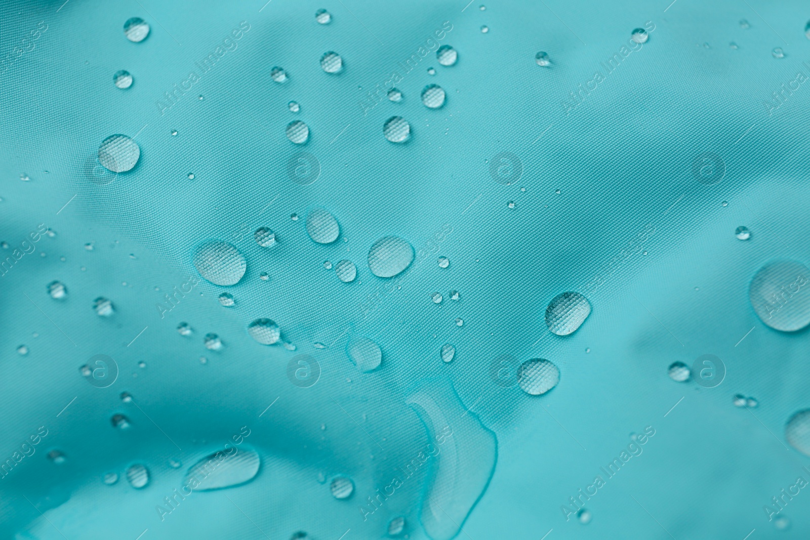 Photo of Turquoise waterproof fabric with water drops as background, closeup