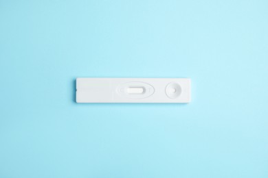 Photo of One disposable express test for hepatitis on light blue background, top view
