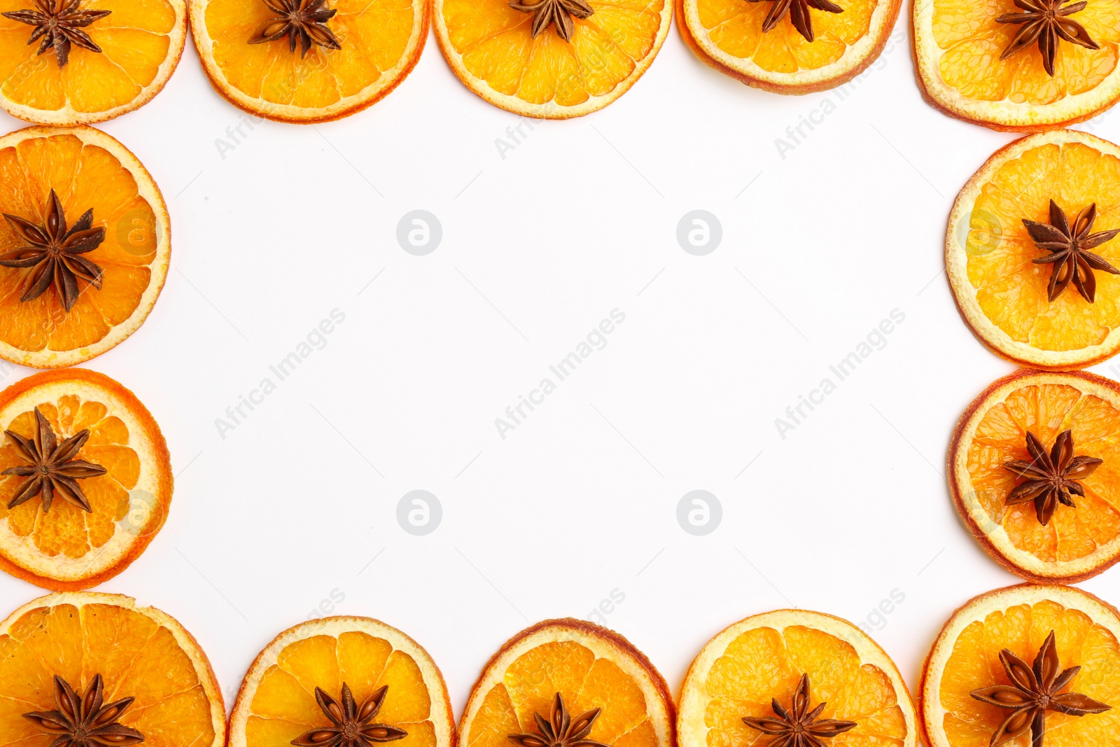 Photo of Frame made of dry orange slices and anise stars on white background, flat lay. Space for text