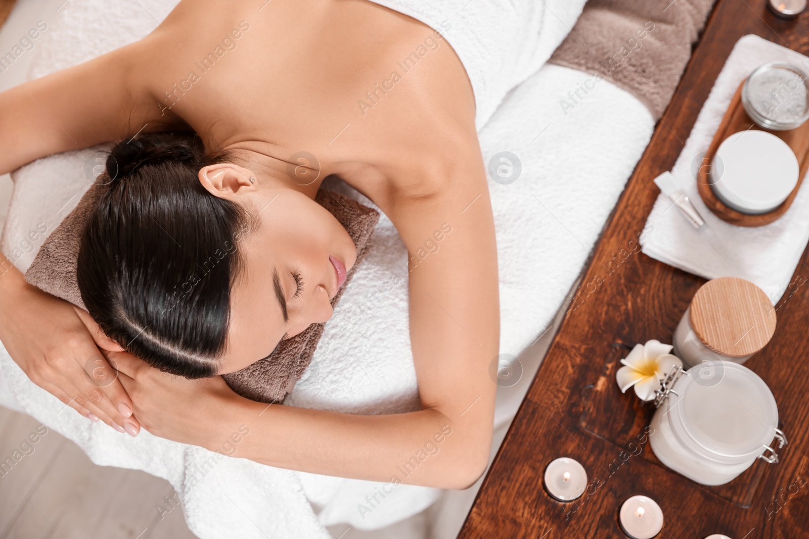 Photo of Young woman resting after professional massage in spa salon, above view