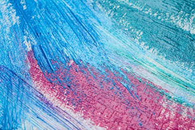 Photo of Strokes of colorful acrylic paints on canvas, closeup