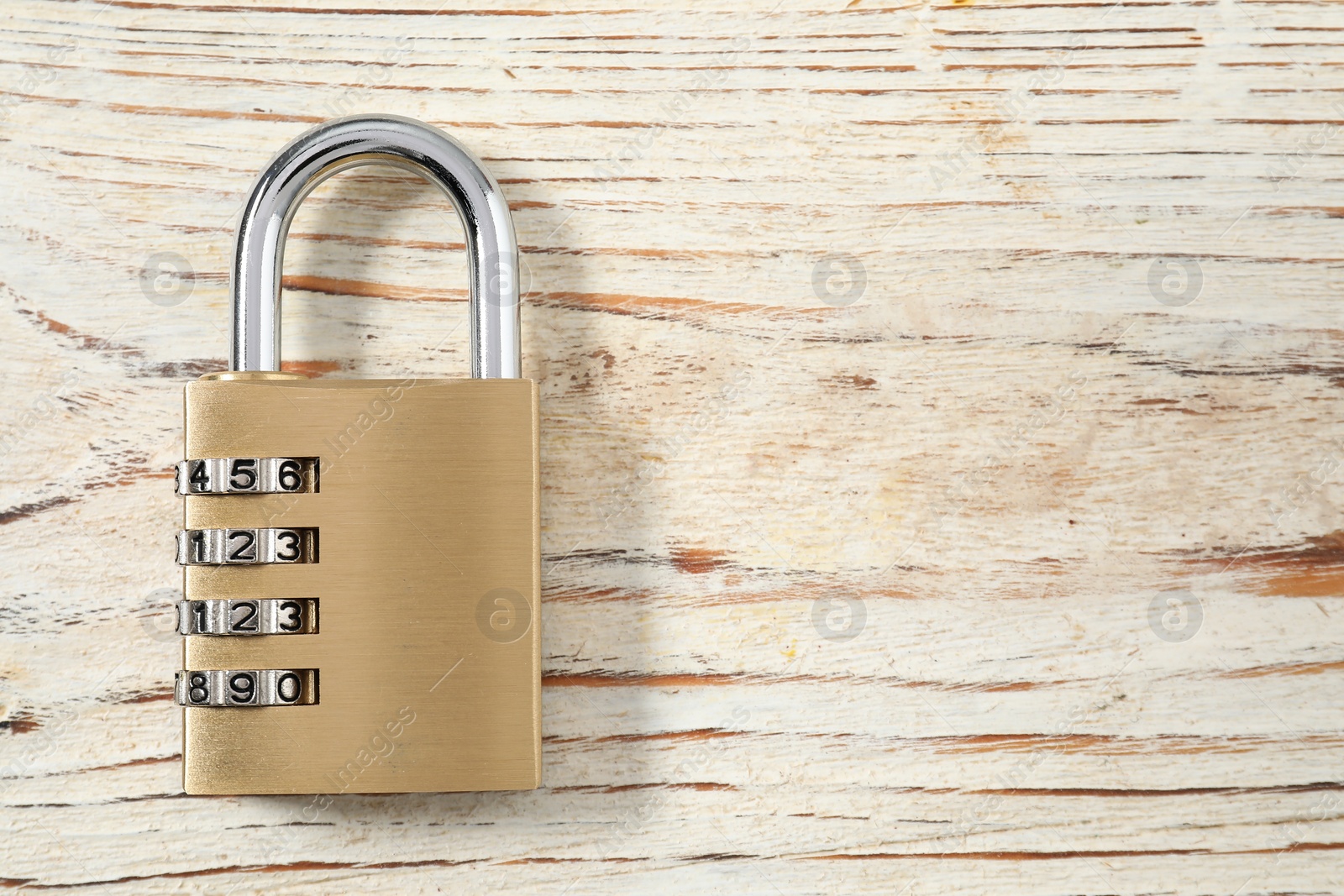 Photo of One steel combination padlock on wooden table, top view. Space for text