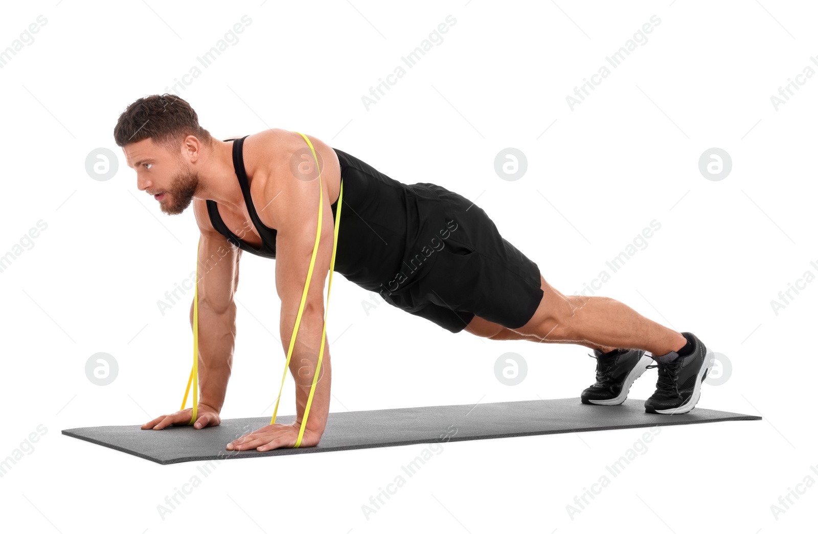 Photo of Young man exercising with elastic resistance band on fitness mat against white background