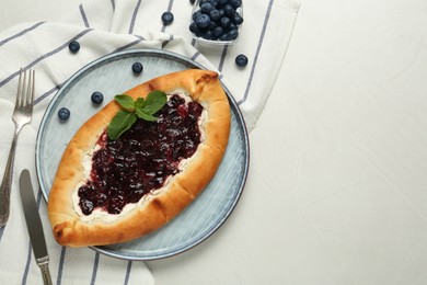 Photo of Delicious sweet cottage cheese pastry with cherry jam served on light table, flat lay. Space for text