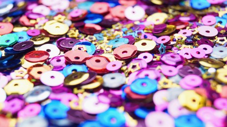 Photo of Many different colorful sequins as background, closeup