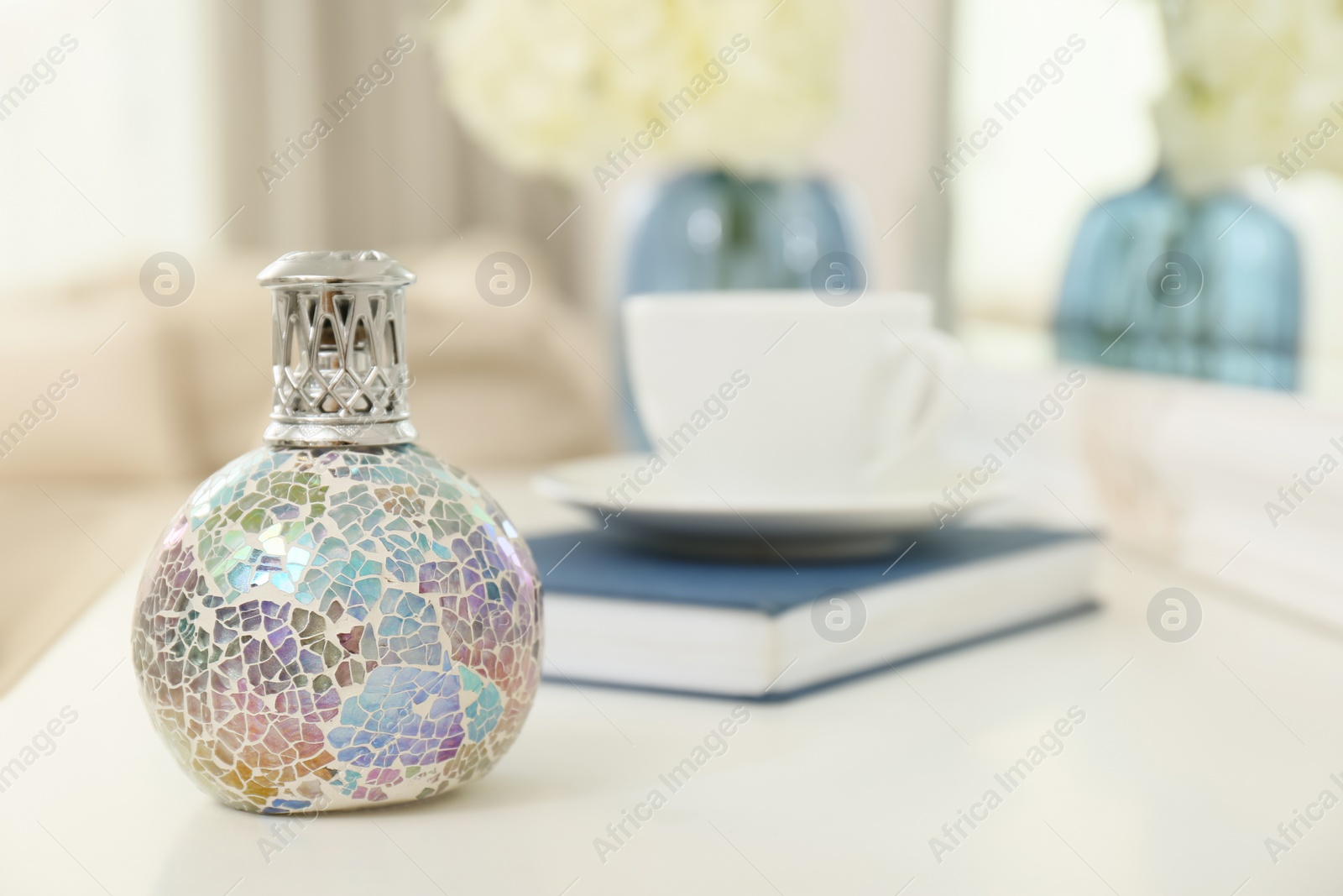 Photo of Stylish catalytic lamp on white table in living room, space for text. Cozy interior