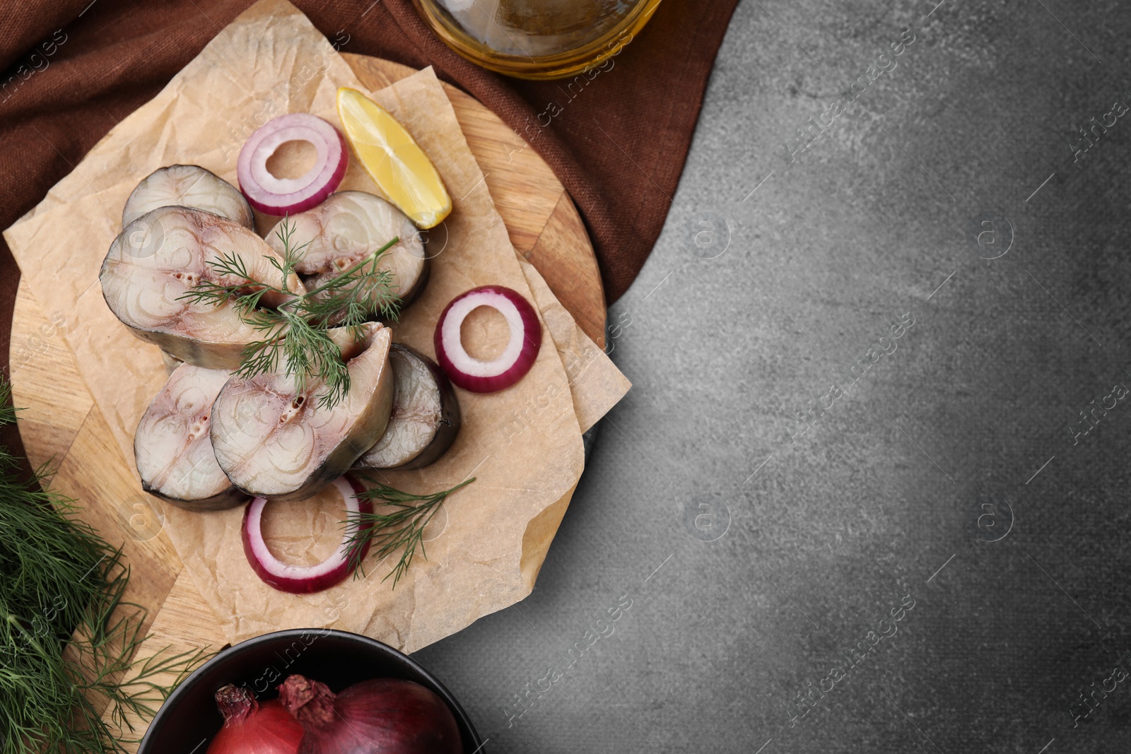 Photo of Slices of tasty salted mackerel served on brown table, flat lay. Space for text