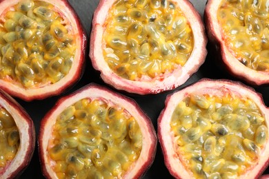 Photo of Halves of passion fruits (maracuyas) on table, flat lay