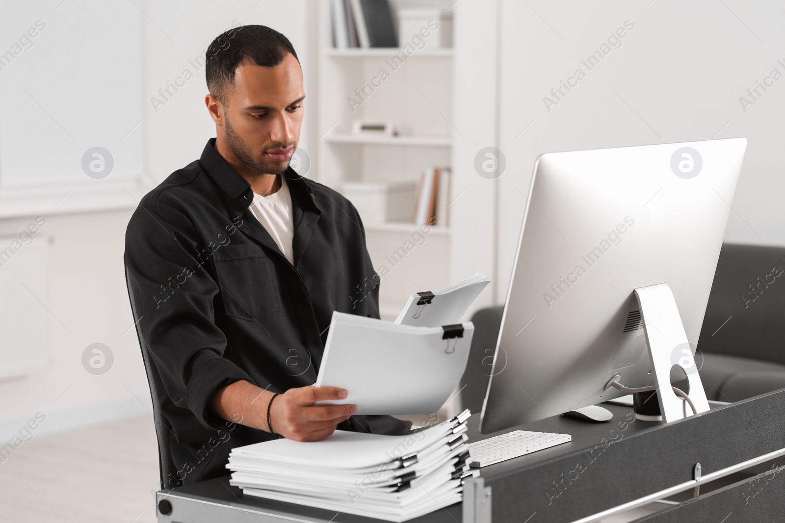 Photo of Man working with documents at grey table in office