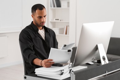 Man working with documents at grey table in office