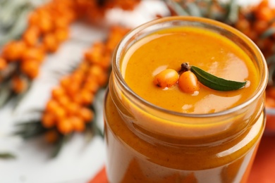 Photo of Delicious sea buckthorn jam in jar, closeup