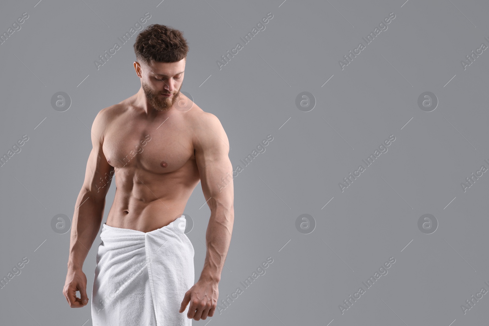 Photo of Muscular man showing abs on grey background, space for text