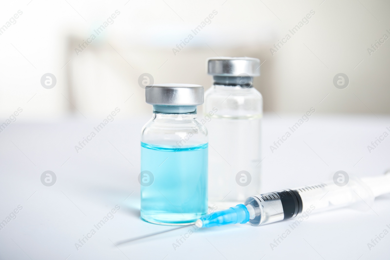 Photo of Vials and syringe on light background. Vaccination and immunization