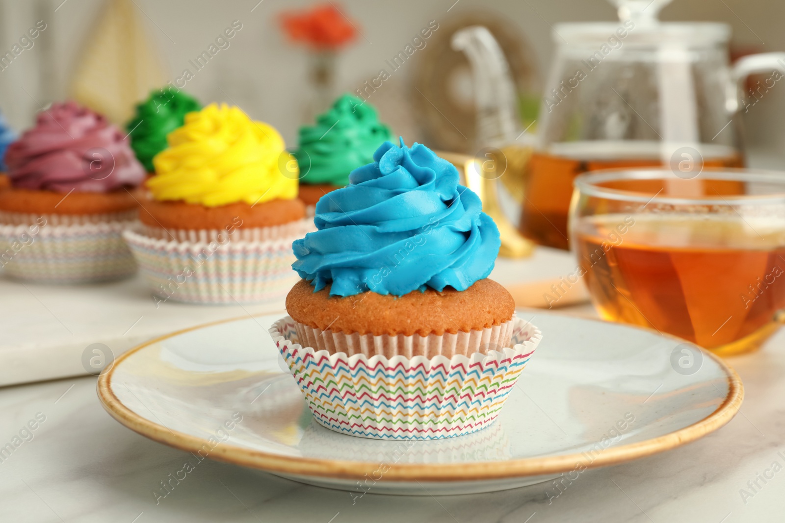 Photo of Delicious cupcake with light blue cream on white table