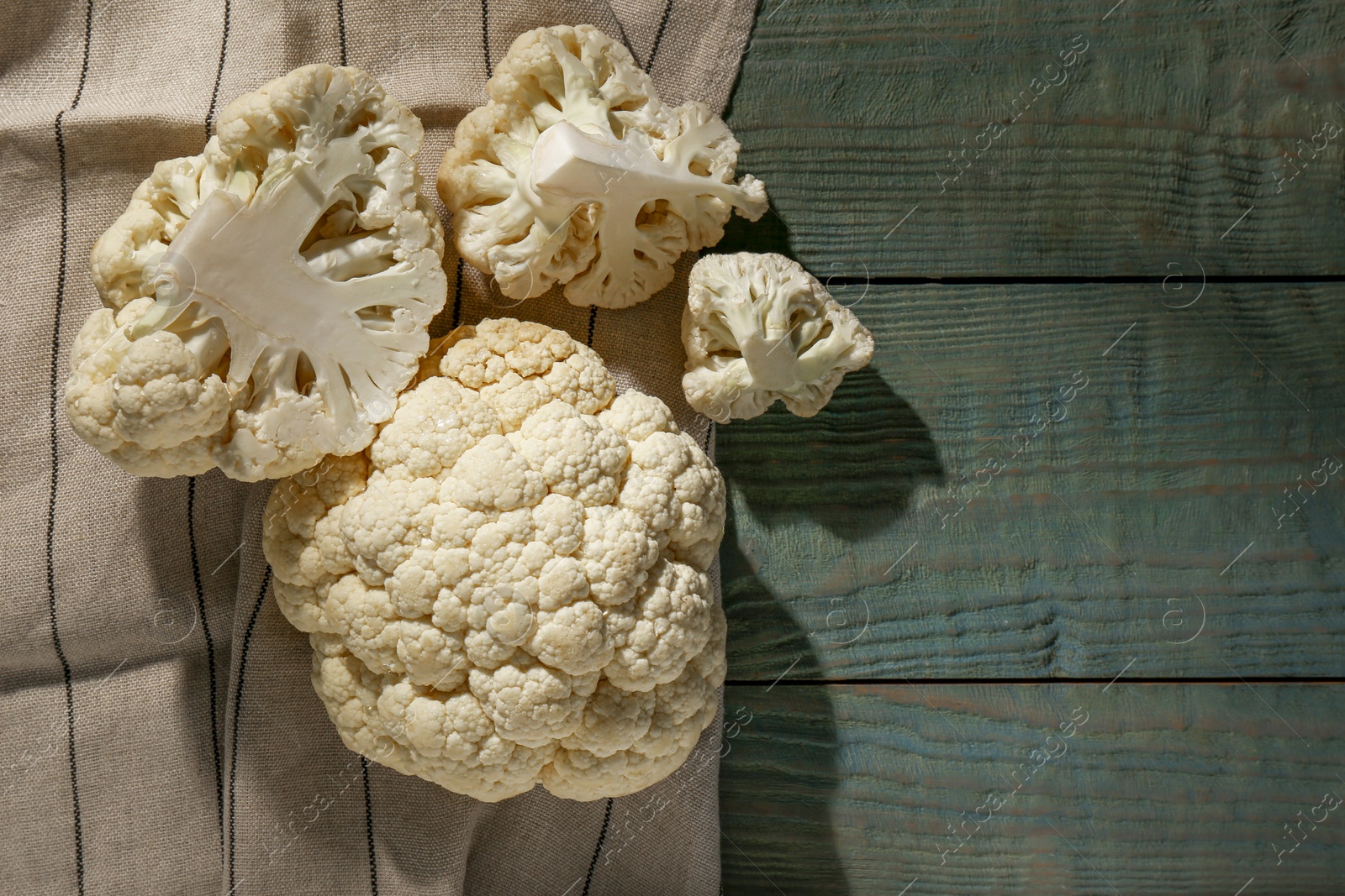 Photo of Fresh raw cauliflower on wooden table, top view. Space for text