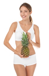 Happy slim woman in underwear holding pineapple on white background. Weight loss diet