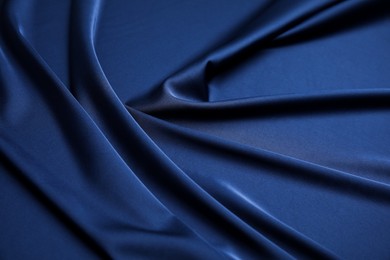 Photo of Crumpled dark blue silk fabric as background, closeup