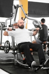 Photo of Overweight man training in gym