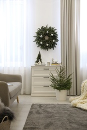 Stylish living room interior with little fir trees and Christmas decorations