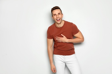 Photo of Portrait of handsome man laughing against light background