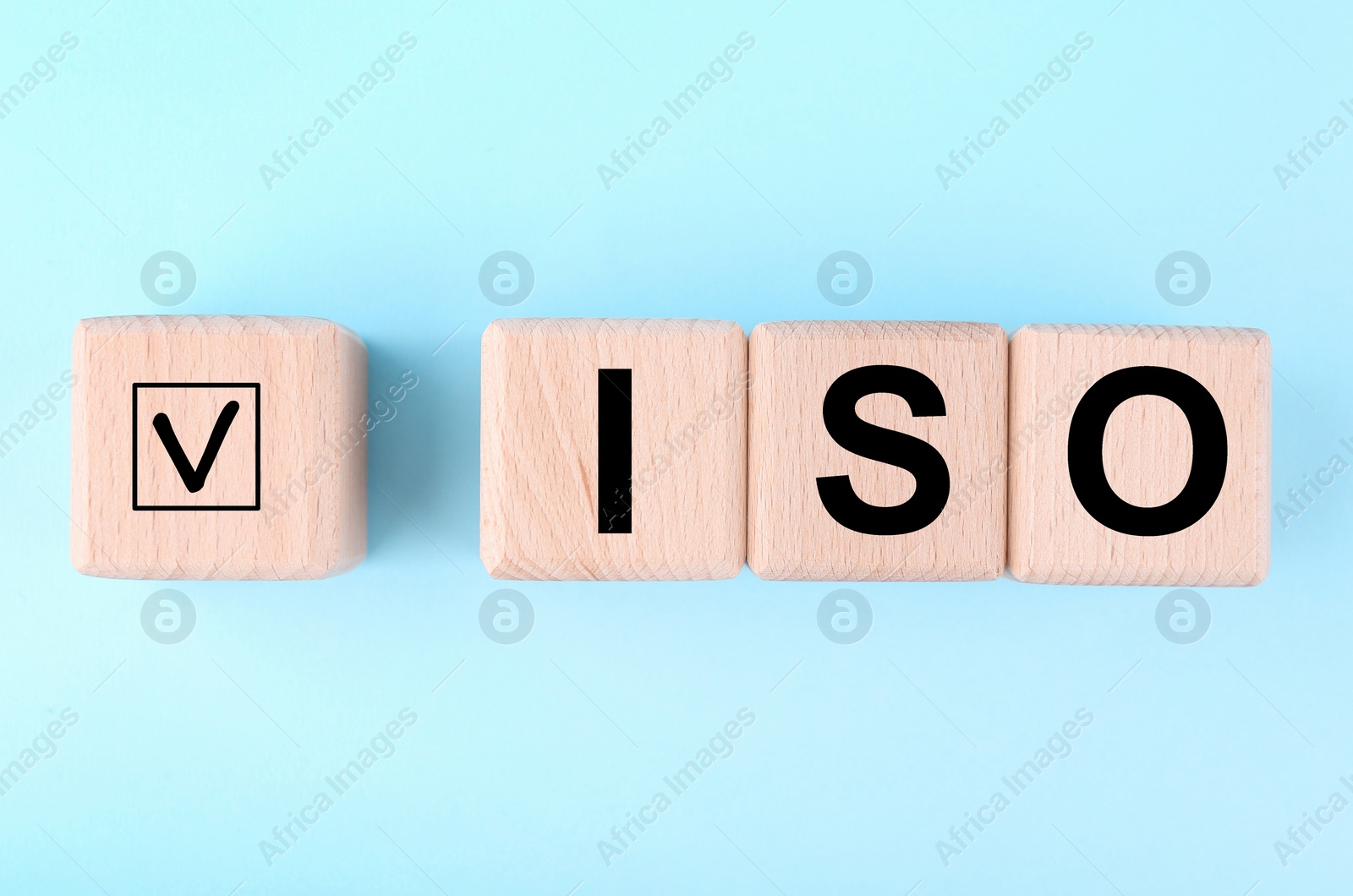 Photo of International Organization for Standardization. Wooden cubes with check mark and abbreviation ISO on light blue background, flat lay