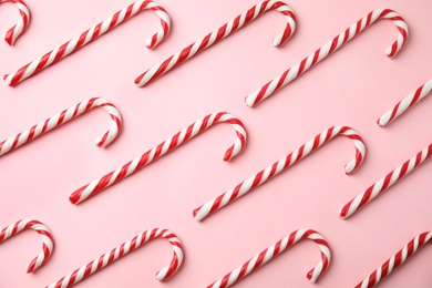 Photo of Flat lay composition with candy canes on pink background