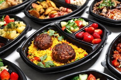 Photo of Lunchboxes with different meals on white table. Healthy food delivery