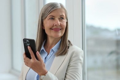 Senior woman using mobile phone at home