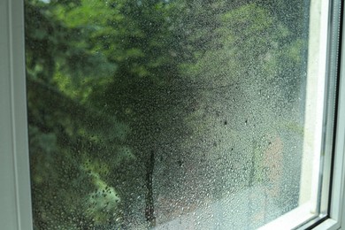 Window glass with water drops, closeup. Condensation