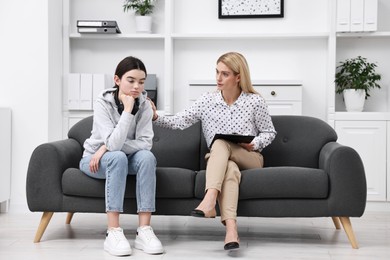 Psychologist working with teenage girl in office