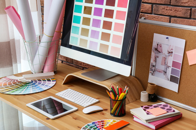 Photo of Modern computer and office supplies on wooden table. Designer's workplace