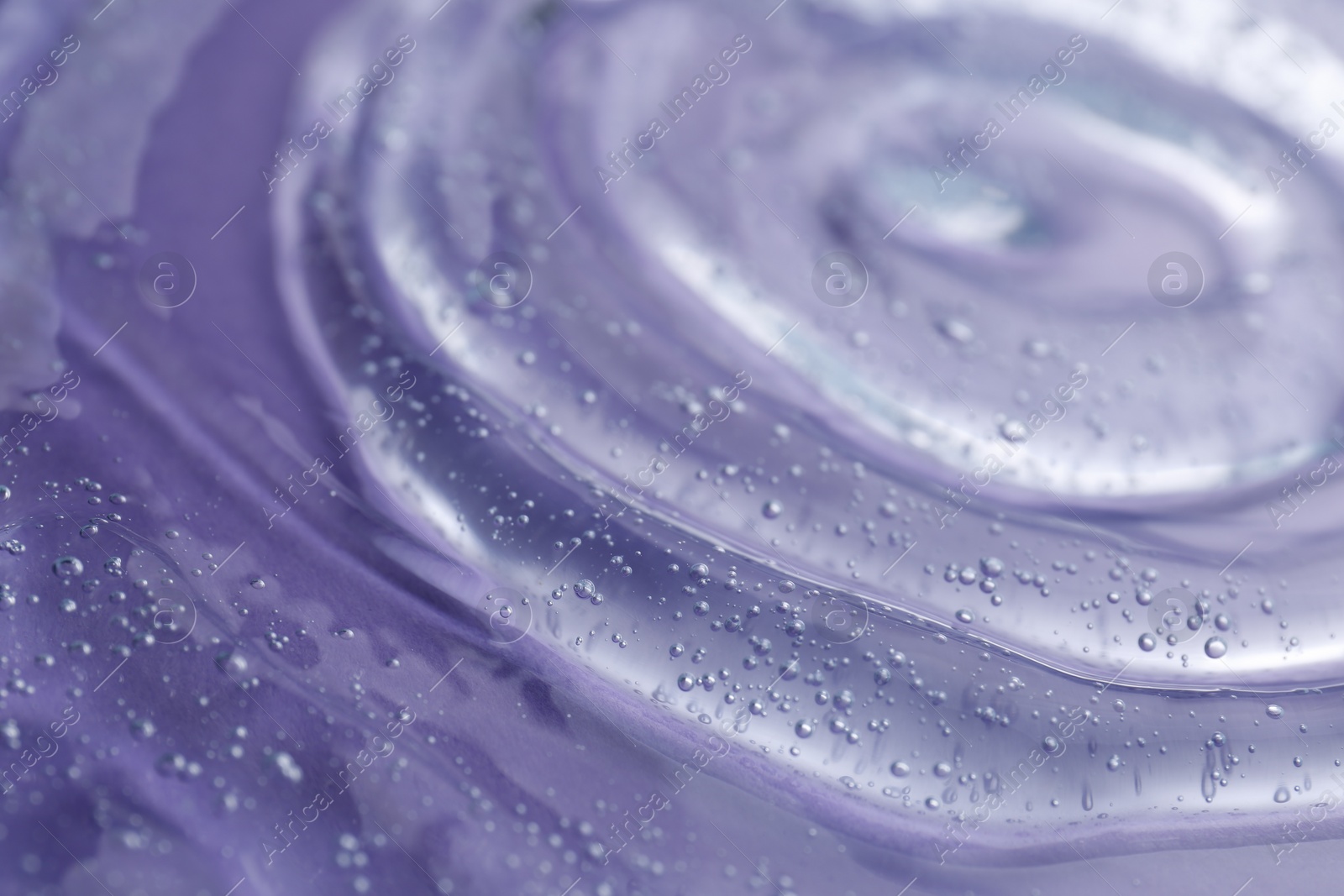 Photo of Transparent shower gel on violet background, closeup