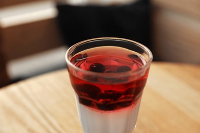 Photo of Delicious panna cotta dessert on wooden table, closeup